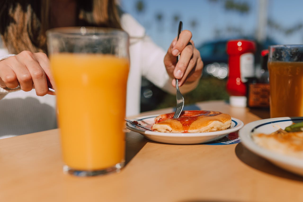 A Woman Slicing Pancake on White Plate